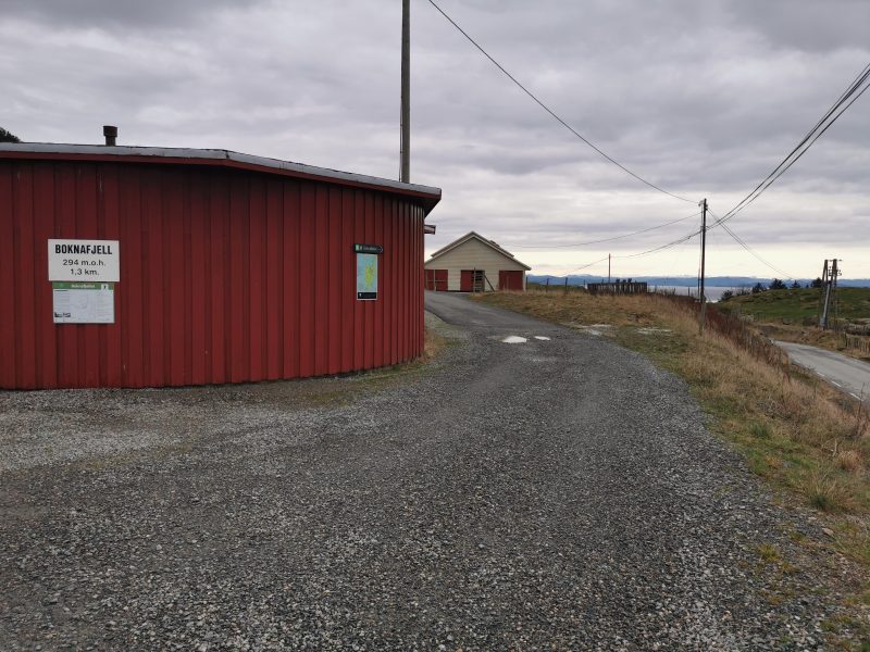 Parkeringsplass ved foten av fjellet. Veien videre er sperret med bom.