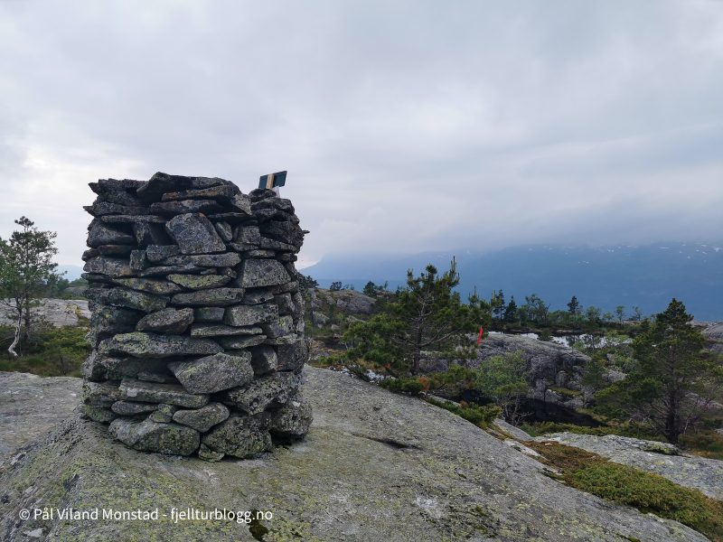 Tåkeskyene henger ned i fjellsidene.